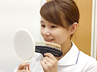 手鏡で自分の歯をチェックする女性